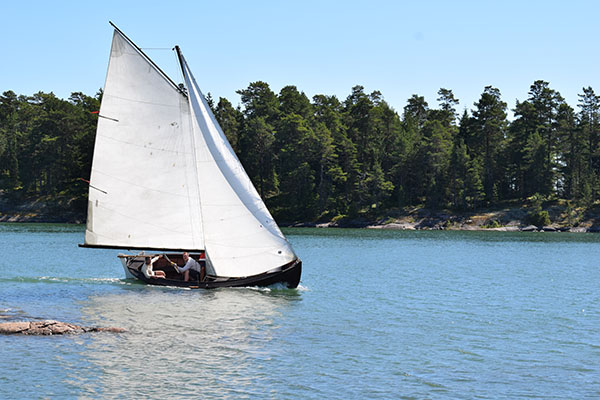 Beautiful boat with white sails racing on the archipelago sea
